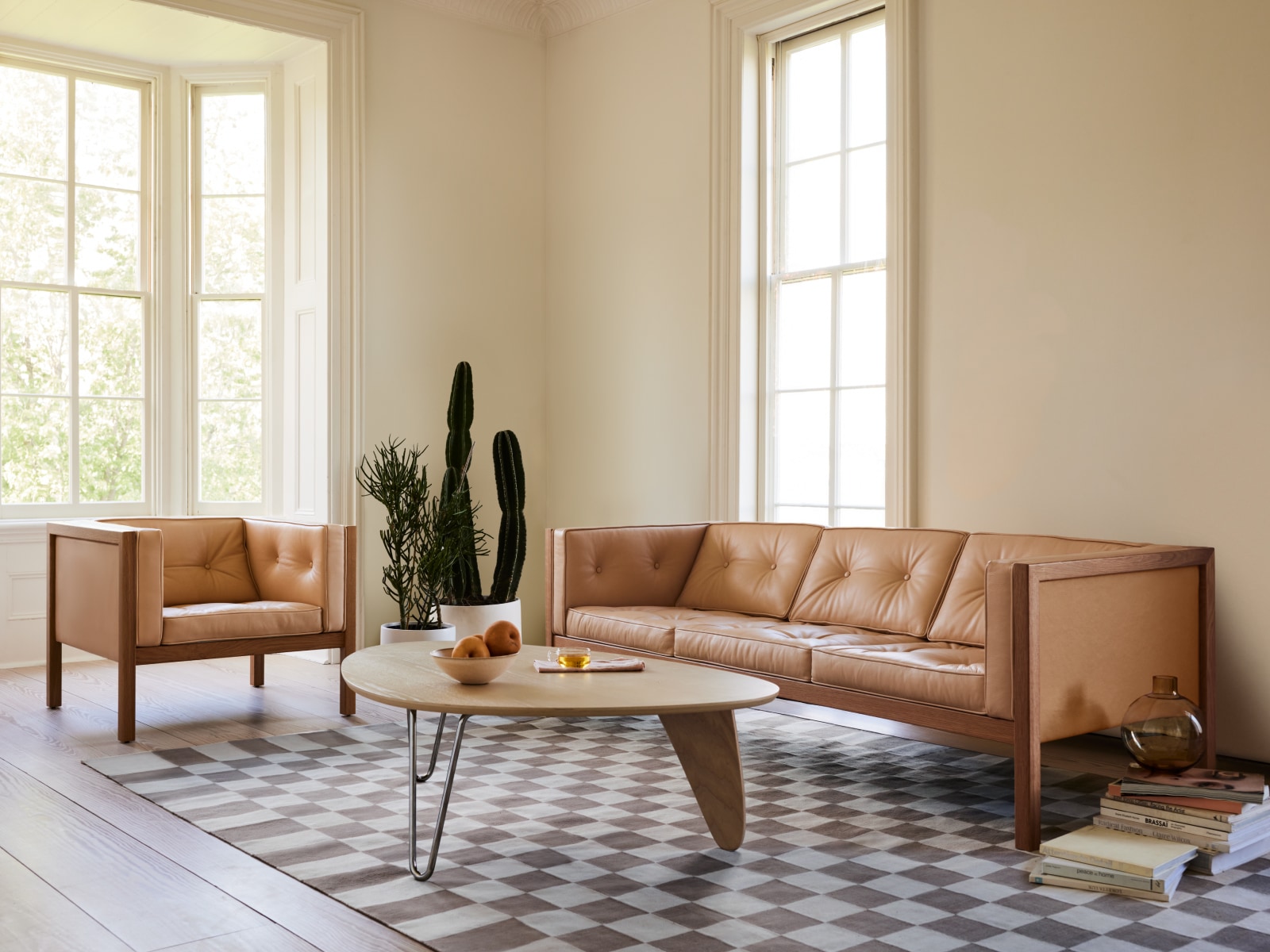 A Noguchi Rudder Table, Girard Check Rug, 80-inch Cube Sofa and Cube Armchair in a living room setting.