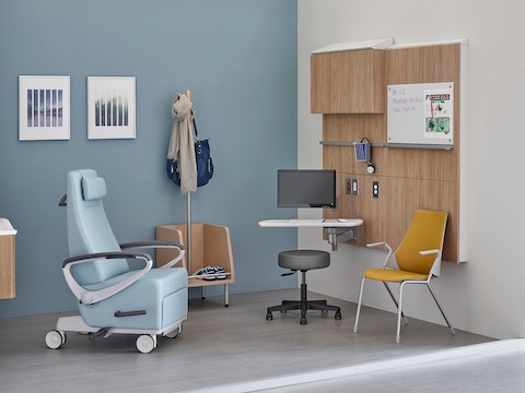 A patient recliner, side chair and stool in an exam room.