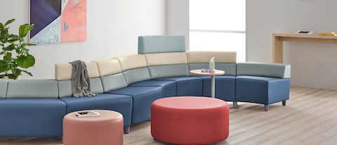 A curved configuration of the Steps Lounge System, featuring modules of blue, light gray and beige with varying back heights.